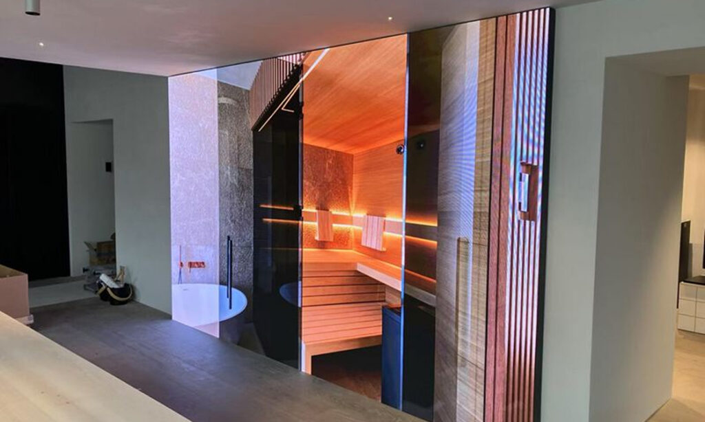 Large indoor LED display wall showing a vivid sauna scene, highlighting seamless aesthetic digital signage integration.
