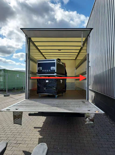 Equipment cases inside an open delivery truck, with a red arrow overlaid.