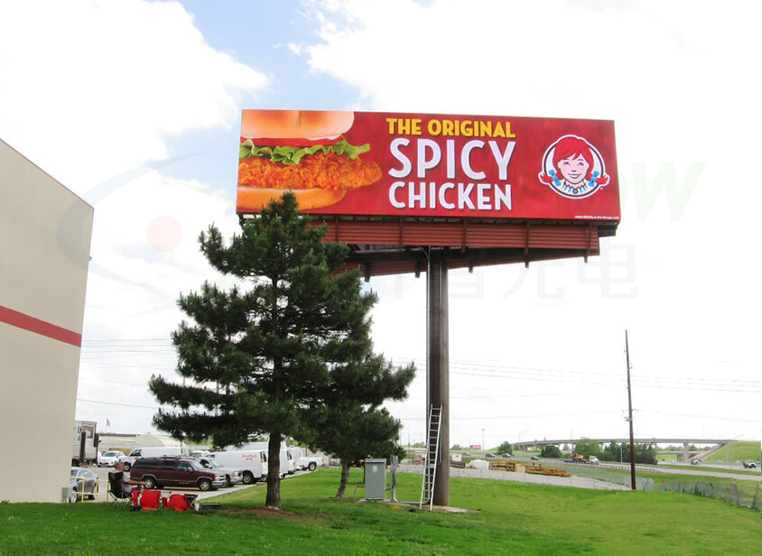 Outdoor Wendy's billboard advertising 'The Original Spicy Chicken' sandwich against a bright, cloudy sky