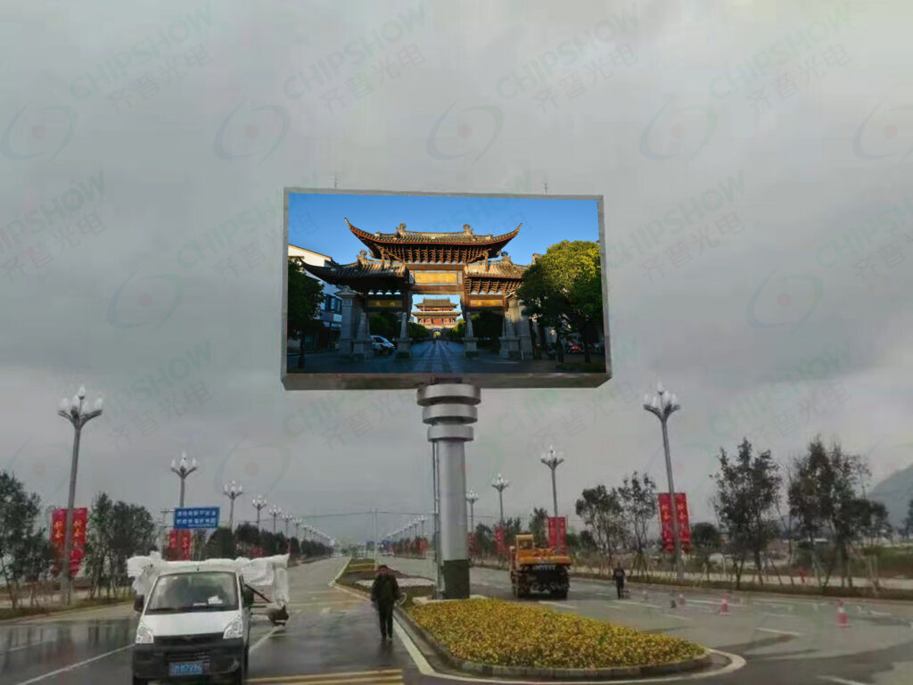 A large freestanding LED billboard displays a traditional Chinese gate at the center of a wide roadway