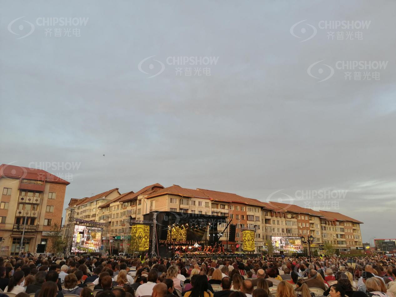 Large-scale outdoor festival stage with relay LED screens for a massive crowd at an open-air public event