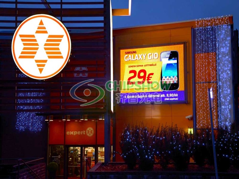 Outdoor wall-mounted LED signage at night promoting a Samsung Galaxy smartphone for 29 Euro at an Expert store
