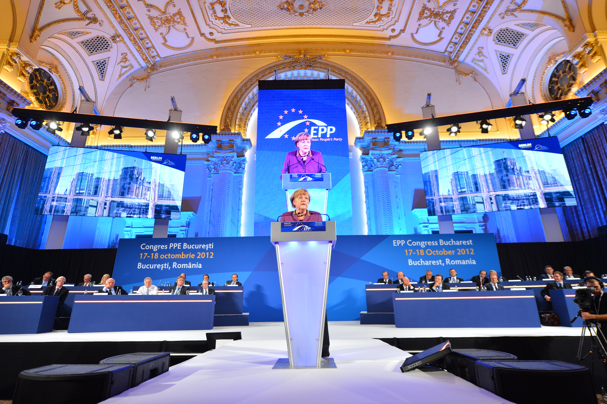 Indoor corporate conference stage in Belgium with large blue LED video wall backdrop and podium