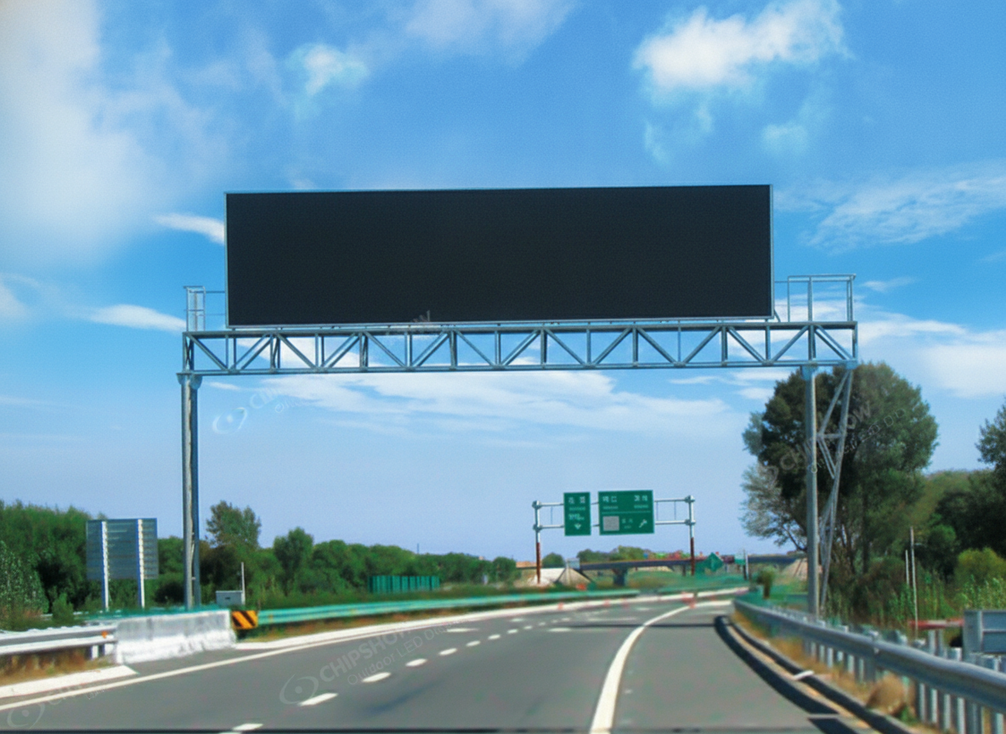 Highway VMS mounted over a multilane road in bright daylight