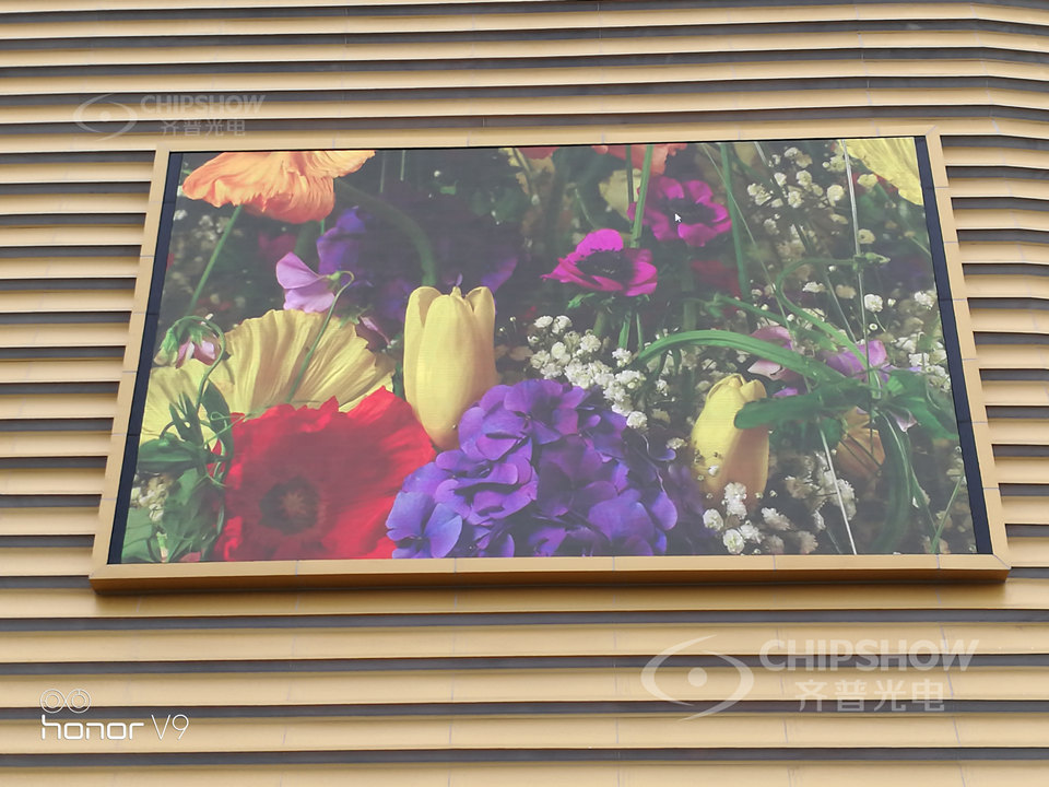 Outdoor LED screen wall-mounted on a building facade, illustrating cabinet alignment, module seams and mounting clearance to inspect.