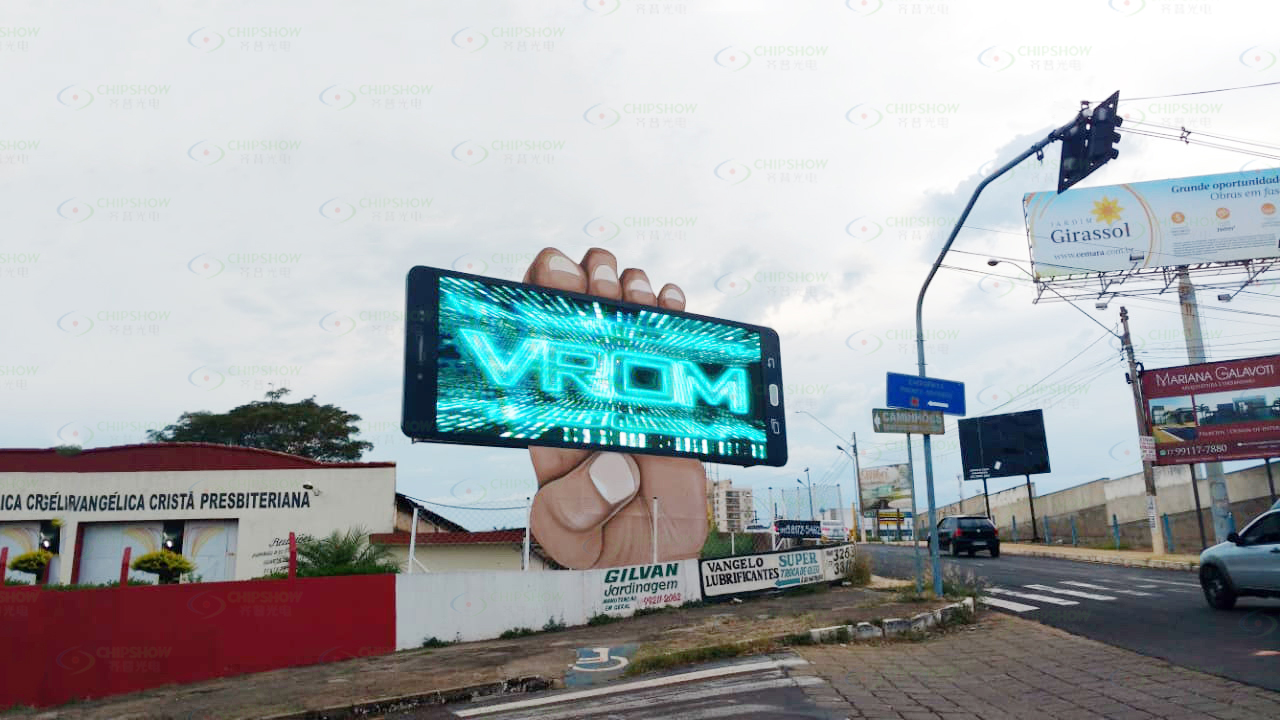 Curved roadside LED billboard positioned ahead of an intersection